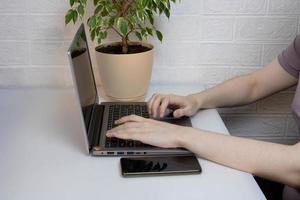 Working in a home office, women's hands on a laptop keyboard photo