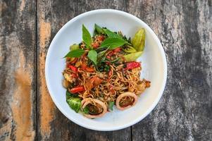 noodles plate with instant noodles stir fried with vegetables herb spicy tasty appetizing asian noodles mix seafood stir fried squid with basil and chilli pepper photo
