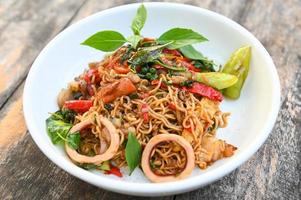 noodles plate with instant noodles stir fried with vegetables herb spicy tasty appetizing asian noodles mix seafood stir fried squid with basil and chilli pepper photo
