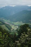 majestuoso montañas en el Alpes cubierto con arboles y nubes foto