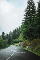 Empty road with a gondola and heavy clouds on the trees nearby Chatel, France photo