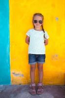 Cute little girl on a colorful wall photo