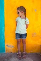 Cute little girl on a colorful wall photo