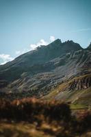 majestuoso montañas en el Alpes cubierto con arboles y nubes foto