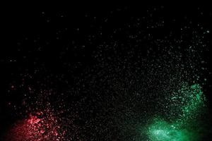 Colorful background of chalk powder. Multicolored dust particles splattered on black background. photo
