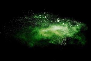 Green color powder explosion cloud on black background.Green dust splash. photo