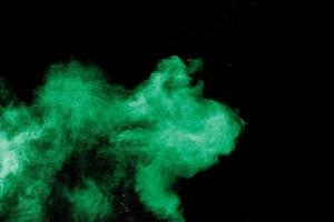 nube de explosión de polvo de color verde sobre fondo negro.salpicadura de polvo verde. foto