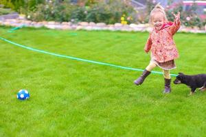 Little girl playing with puppy dog photo