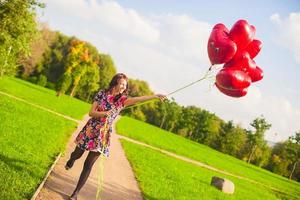 Woman holding heart shaped balloons photo