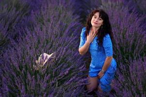 Portrait of a happy woman in a blue dress enjoying a sunny summer day in a lavender field. Fresh air, Lifestyle. photo