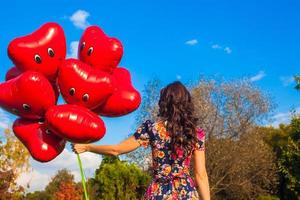 mujer con corazón conformado globos foto