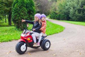 pequeño muchachas en un eléctrico motocicleta foto