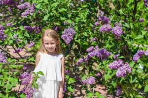 pequeño niña con flores en el jardín foto