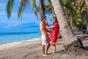 Couple by a palm tree on the beach photo