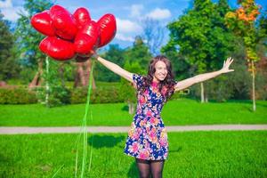 Young woman with red heart balloons photo