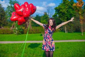 joven mujer con rojo corazón globos foto