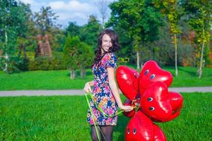 joven mujer con rojo corazón globos foto