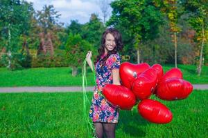 joven mujer con rojo corazón globos foto