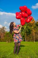 joven mujer con rojo corazón globos foto