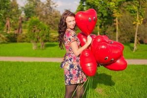 joven mujer con rojo corazón globos foto