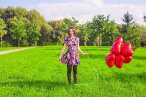 joven mujer con rojo corazón globos foto