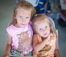 hermosa pequeño hermanas esperando en el aeropuerto foto