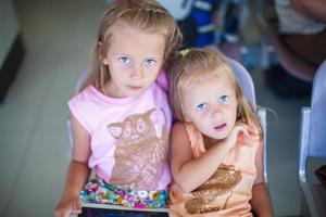 hermosa pequeño hermanas esperando en el aeropuerto foto