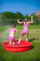 pequeño hermanas teniendo divertido en el verano foto