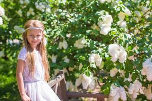 pequeño niña con hermosa flores foto