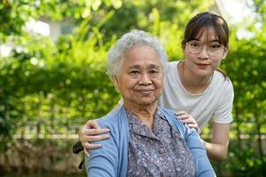 caregiver help and care Asian senior woman patient sitting on wheelchair at nursing hospital ward, healthy strong medical concept. photo