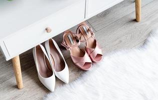 closeup of elegant high heel shoes standing under feminine dressing table photo