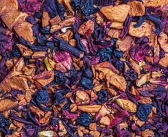 Background of natural fruit tea with hibiscus petals, fruit slices and berries. Fruit tea texture. Top view, flat lay. photo
