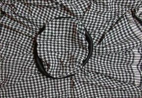 Background texture, pattern. Scarf wool like Yasser Arafat. The Palestinian keffiyeh is a gender-neutral checkered black and white scarf that is usually worn around the neck or head. photo