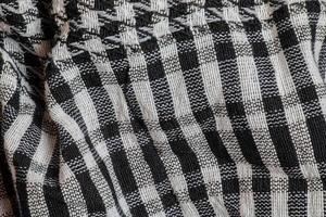 Background texture, pattern. Scarf wool like Yasser Arafat. The Palestinian keffiyeh is a gender-neutral checkered black and white scarf that is usually worn around the neck or head. photo