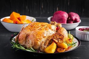 horneado Turquía o pollo. el Navidad mesa es servido con un pavo, decorado con brillante oropel. frito pollo, mesa ajuste. Navidad cena. foto