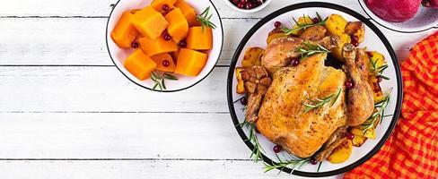 Baked turkey or chicken. The Christmas table is served with a turkey, decorated with bright tinsel. Fried chicken. Table setting. Christmas dinner. Banner. Top view photo
