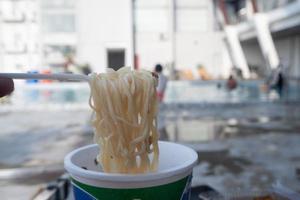 selective focus on noodles with a blurry swimming pool background, soft focus photo