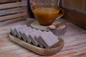 selective focus to square chocolate biscuit wafer on wooden plate, soft focus photo