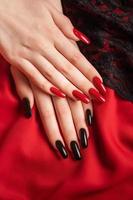 Hands of a young girl with black and red manicure on nails photo