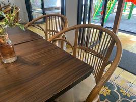 interior de restaurante con de madera mesa y de madera ornamento. vacío asiento y mesa en restaurante. cerca arriba limpiar mesa y silla foto