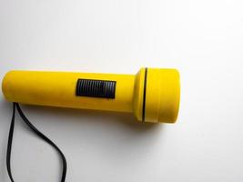 yellow flashlight on white background. copy space. flashlight for blackout and emergency. selected focus photo