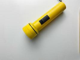 yellow flashlight on white background. copy space. flashlight for blackout and emergency. selected focus photo