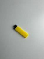 yellow lighter isolated on white background. hand tried to lit yellow lighter. copy space. selected focus photo