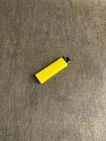 yellow lighter isolated on white background. hand tried to lit yellow lighter. copy space. selected focus photo