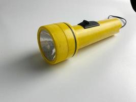 yellow flashlight on white background. copy space. flashlight for blackout and emergency. selected focus photo