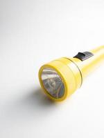 yellow flashlight on white background. copy space. flashlight for blackout and emergency. selected focus photo