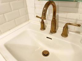 Interior of bathroom with retro classic washbasin and gold faucet. Bathroom interior sink with classic design in luxury hotel. photo