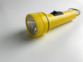 yellow flashlight on white background. copy space. flashlight for blackout and emergency. selected focus photo