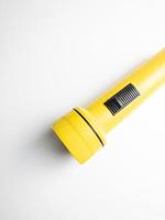 yellow flashlight on white background. copy space. flashlight for blackout and emergency. selected focus photo