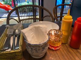 condiment at restaurant. tissue, candle, and sauces essential at the table restaurant photo